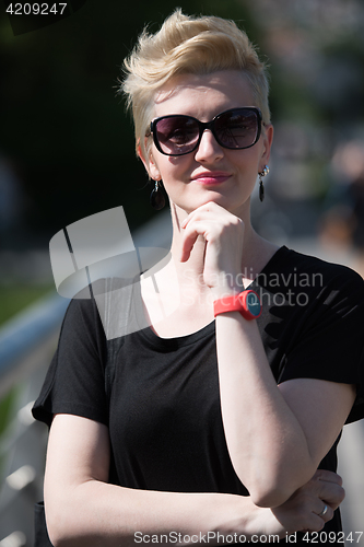 Image of young woman with short blond hair and sunglasses