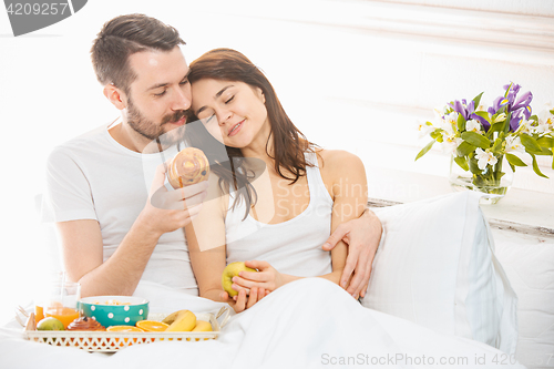 Image of Relaxed Couple in Bed in bedroom at home