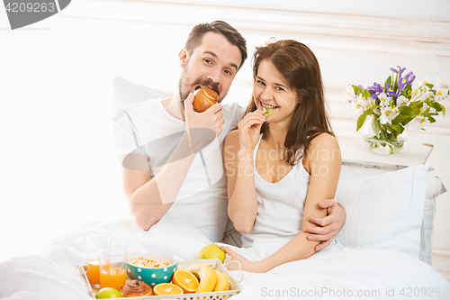 Image of Relaxed Couple in Bed in bedroom at home