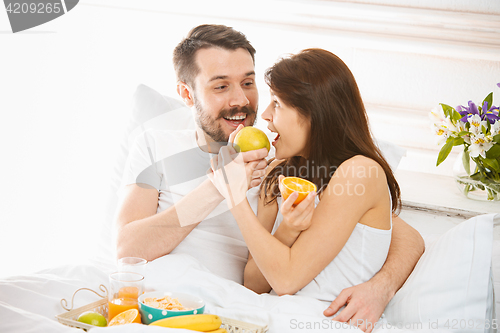 Image of Relaxed Couple in Bed in bedroom at home