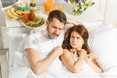 Image of Relaxed Couple in Bed in bedroom at home