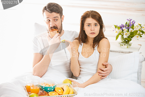 Image of Relaxed Couple in Bed in bedroom at home