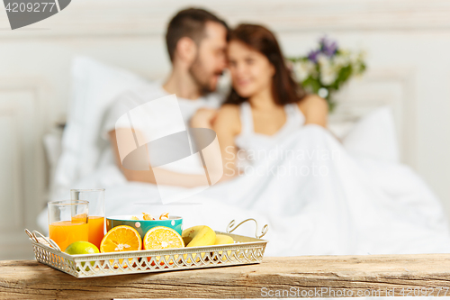 Image of Relaxed Couple in Bed in bedroom at home