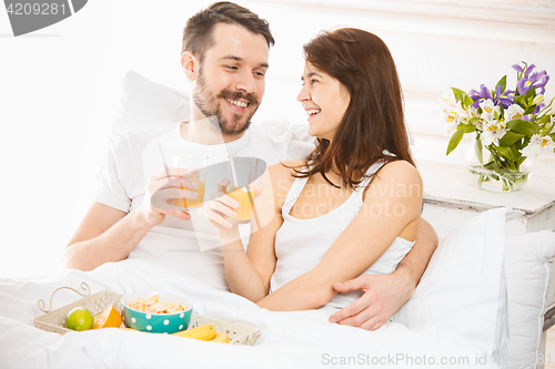 Image of Relaxed Couple in Bed in bedroom at home