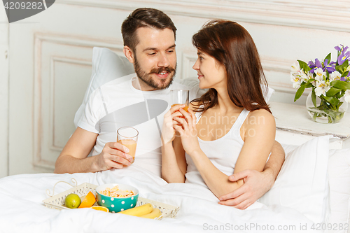 Image of Relaxed Couple in Bed in bedroom at home