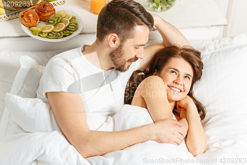 Image of Relaxed Couple in Bed in bedroom at home