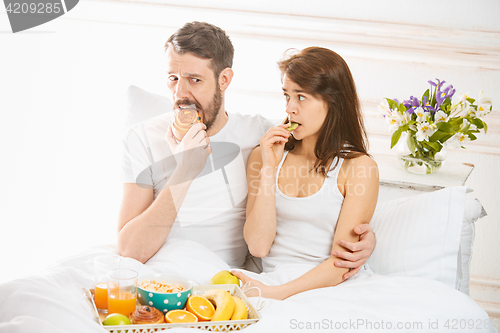 Image of Relaxed Couple in Bed in bedroom at home