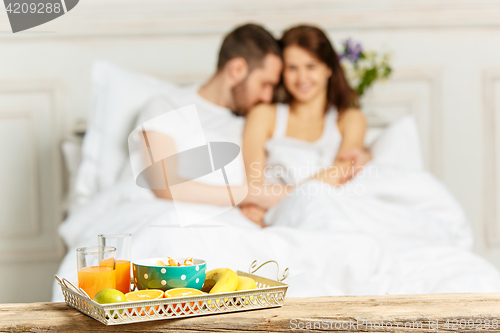 Image of Relaxed Couple in Bed in bedroom at home