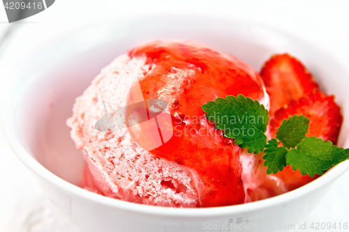 Image of Ice cream strawberry with syrup in bowl on board