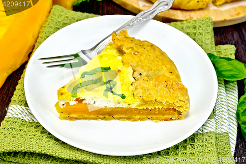 Image of Pie of pumpkin and cheese in plate on green napkin