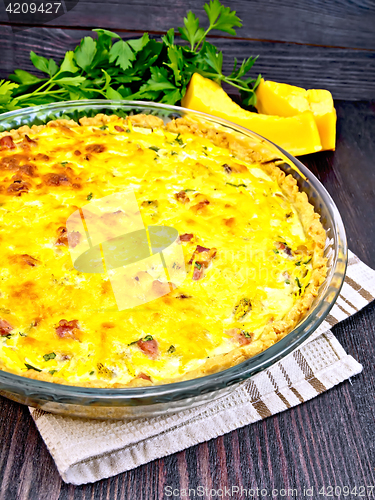 Image of Quiche with pumpkin and bacon in pan on dark board