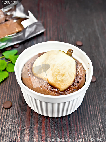 Image of Cake with chocolate and pear in white bowl on board