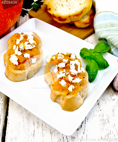 Image of Bruschetta with pumpkin and cheese in white plate on light board