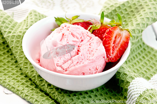 Image of Ice cream strawberry with berries in bowl on napkin