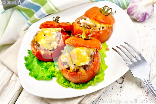 Image of Tomatoes stuffed with rice and meat in plate on board