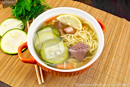 Image of Soup with zucchini and noodles on bamboo