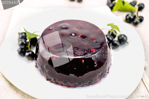 Image of Jelly from black currant with berries in plate on napkin