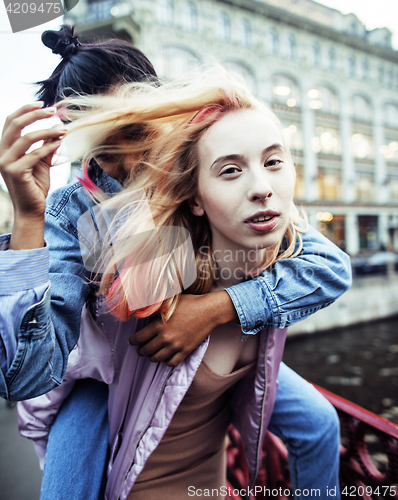 Image of Two teenage girls infront of university building smiling, having