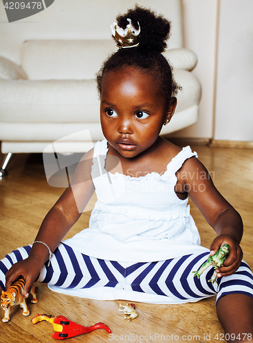 Image of little cute african american girl playing with animal toys at ho