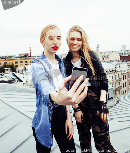 Image of two cool blond real girls friends making selfie on roof top, lif