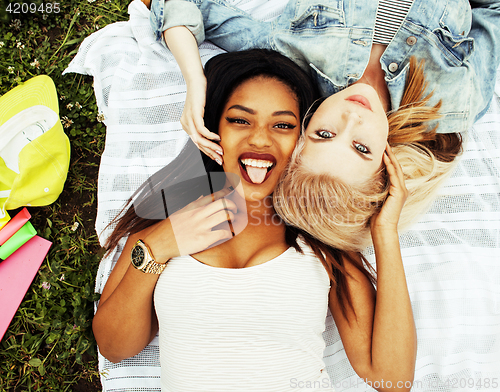 Image of two young pretty teenager girls best friends laying on grass mak