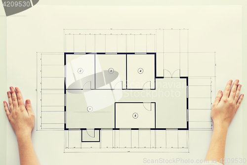 Image of close up of hands with architectural blueprint