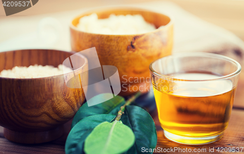 Image of close up of honey in glass with leaves on wood