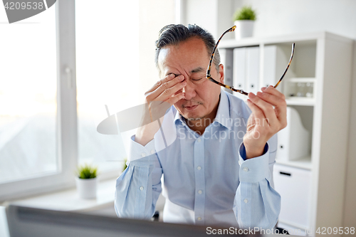 Image of tired businessman with glasses at laptop in office