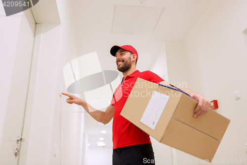 Image of delivery man with parcel box ringing doorbell