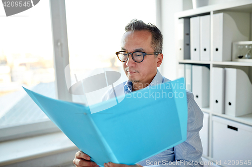 Image of businessman with folder and papers at office