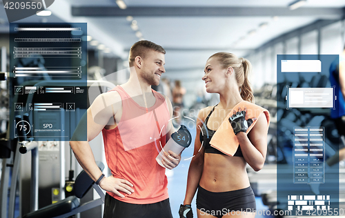 Image of smiling man and woman talking in gym