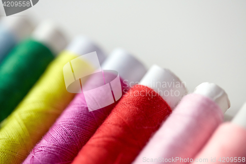 Image of row of colorful thread spools on table