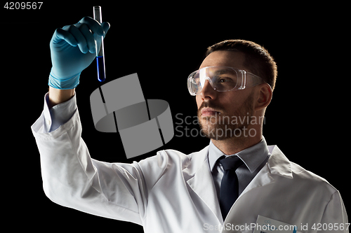 Image of scientist in safety glasses with test tube