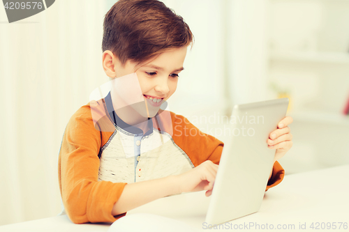 Image of smiling boy with tablet pc computer at home