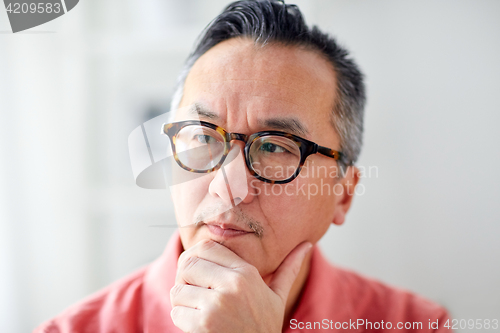 Image of close up of asian man thinking at home