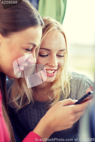 Image of happy young women in travel bus with smartphone