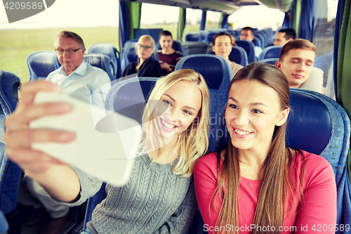 Image of women taking selfie by smartphone in travel bus