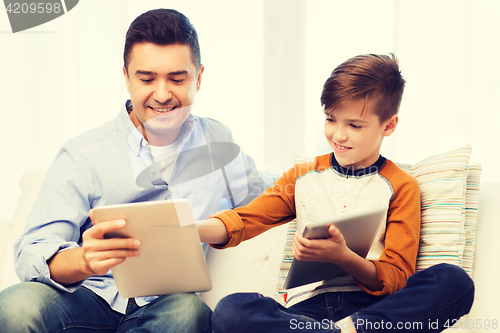 Image of happy father and son with tablet pc at home