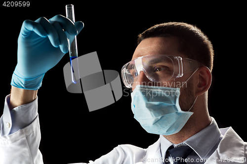 Image of scientist with safety glasses, mask and test tube