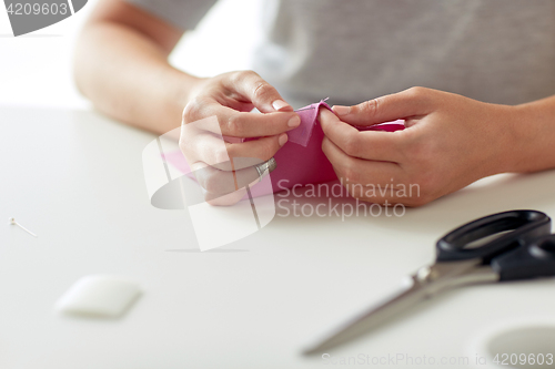 Image of woman with needle stitching fabric pieces