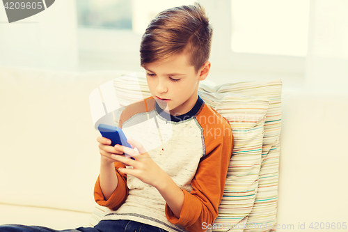 Image of boy with smartphone texting or playing at home