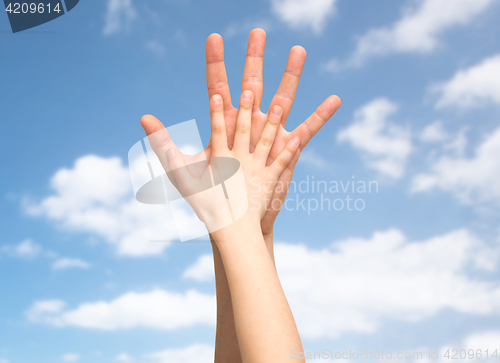 Image of father and child holding hands together over sky