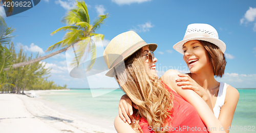 Image of happy young women in hats on summer beach