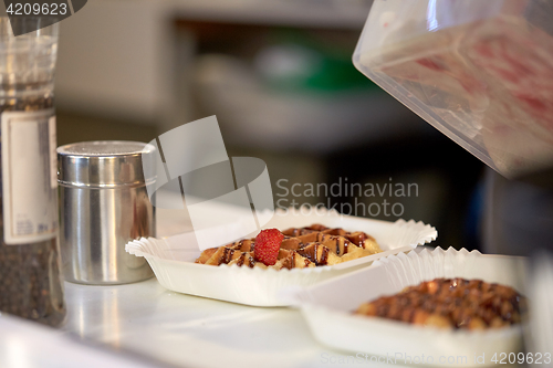 Image of waffle with strawberry on paper plate and fork