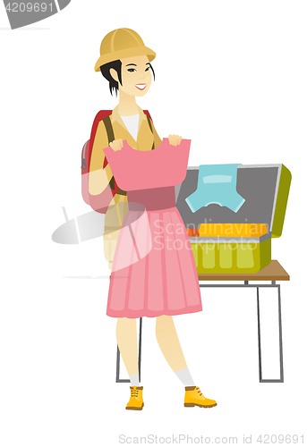 Image of Asian traveler woman packing suitcase.