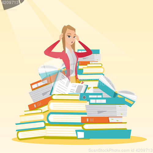 Image of Student sitting in huge pile of books.