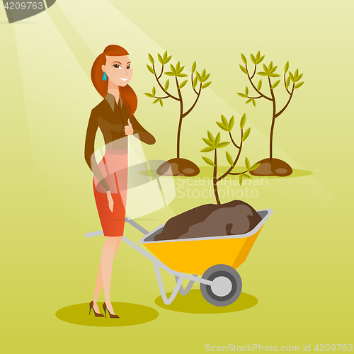 Image of Woman pushing wheelbarrow with plant.