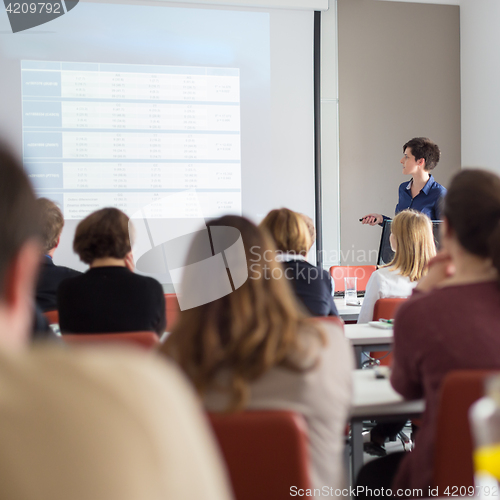 Image of Woman giving presentation in lecture hall at university.