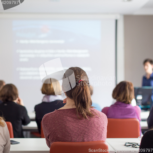 Image of Woman giving presentation in lecture hall at university.