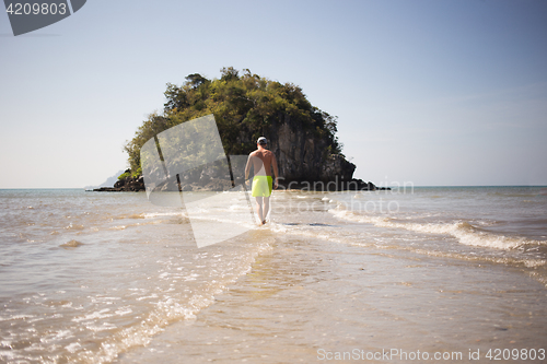 Image of Young man walks by seashore